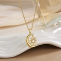 Macro shot of gold-plated sun and moon pendant with shimmering zircon on white tray - Moon and Sun Celestial Series (XL0321)