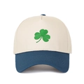 Close-up of green clover embroidery on a beige and navy blue two-tone baseball cap - Beige Crown + Dark Blue Brim