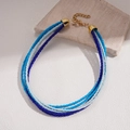 Dettaglio della collana bohémien a più strati in perline blu e bianche con chiusura oro - Collana-Blu-Bianco