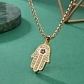 Collar de mano de Fátima dorado con cristales sobre fondo verde texturizado de lujo - Colgante con Cadena de Perlas / Dorado