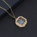 Detailed close-up of golden octagonal pendant with iridescent crystal and zirconia stones - Colorful