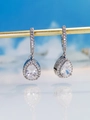 Macro shot of silver teardrop earrings with pear-cut crystals and halo pavé diamonds - White