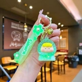 Dettaglio portachiavi Sakura verde con bambola traslucida e campanellino dorato appeso - Stile Statuina Durian con Bolle Luminose e Corda Sakura / Verde