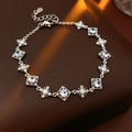 Close-up of adjustable silver zircon bracelet with cross floral links on leather background - Square Frame with Floral Link Style