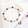 Detalle de pulsera de dijes de corazón con purpurina multicolor y acabado dorado en seda - Pulsera de Corazón