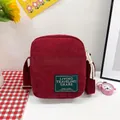 Burgundy corduroy crossbody bag with green label and adjustable fabric strap - Burgundy