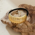Eleganter Haargummi mit goldenem Metall-Bambusgelenk auf einem Naturstein-Hintergrund - Bambusstreifen-Stil (x3dr3)
