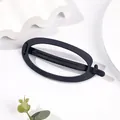 Detailed view of large black matte hair claw clip with elegant oval cutout on white pedestal - Oval - Navy Blue