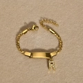Close-up of golden stainless steel Cuban bracelet with rectangle ID plate and letter R charm - Gold Letter R