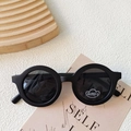 Retro matte black round frame sunglasses with UV400 lenses on a minimalist beige background - Black