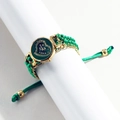 Detail of heart-shaped green dial watch with rhinestone scales and woven bracelet band - Gold Case Green Dial