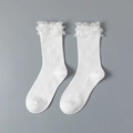 White ribbed short socks with delicate ruffled lace cuffs shown in a flat lay view - White