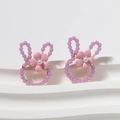 Dettaglio di orecchini a coniglio con perle viola, fiore rosa e perla bianca - Viola