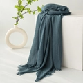 Linen cotton scarf in dark teal with frayed edges on white minimalist background - Cyan