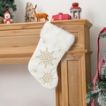 Detailed view of white plush Christmas stocking with gold snowflake embroidery on a fireplace - Gold Snowflake