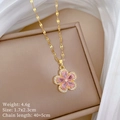 Close-up van gouden bloemketting met roze edelsteen op beige juwelendoosje - Roze Bloem Ketting