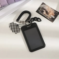 Close-up of black card holder with spring rope and checkered cloud charm accessory - Black Vertical (With Checkerboard Pendant)