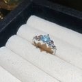 Detalle macro de anillo de plata con flor, piedra central azul y brillantes detalles de circón - Estilo Flor Azul Plateado