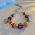 Detailed view of handmade ethnic bracelet with turquoise beads and silver Fu pendant - Four-Leaf Clover: Hand-Rubbed Cotton Bracelet