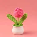 Close-up of handmade crochet pink tulip in a white ceramic pot with green leaves - Rose Red Single Head Tulip