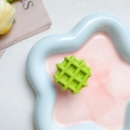 Dettaglio del supporto per cellulare a forma di waffle verde su un piatto decorativo - Verde