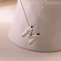 Macro detail of silver puffy letter M pendant with a delicate box chain necklace - Letter M - Silver
