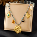 Braided necklace with gold flower, heart charms and turquoise pendant on beige jewelry pad - Flower Turquoise Blue Purple Rope Necklace (N3612)