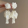 Detail of white floral tassel earrings with pearl luster petals and golden metal links - 20# Silver Needle - White