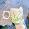 Close-up of white ceramic mug featuring embossed yellow tulip pattern and round yellow handle - Single Cup / Yellow