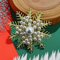 Golden Christmas snowflake brooch with embedded pearls on a festive holiday background - Snowflake 4 Pearl