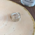 Detail of multi-layer silver star ring showing wire wrap design on ceramic dish - Multilayer Wrap Open Ring / Silver