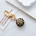 Golden Evil Eye keychain with blue faceted crystal and sunburst design on a white background - Gold Triangle Eye
