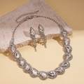 Vista dettagliata della collana con strass a goccia d'argento e orecchini a nappa coordinati - Set di collana e orecchini da 2 pezzi / Bianco