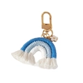Close-up of hand-woven blue and white cotton rainbow keychain with gold clasp and floral charm - Sapphire Blue