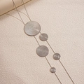 Detail shot of silver long tassel necklace with textured circular metal pendants and layers - Necklace / Silver