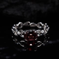 Macro shot of silver chain ring featuring a large oval deep red garnet on a black surface - Natural Garnet Vintage Ring LR342