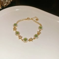 Detail view of gold-plated emerald flower bracelet with sparkling crystals and lobster clasp - Gold Round Cat's Eye Star Style