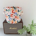 Close-up of quilted storage basket showing colorful abstract patterns and side handles - Height 17cm x Bottom Diameter 20cm / Multicolor Abstract Geometric (UU)