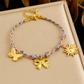 Handmade woven cord bracelet with gold-plated butterfly and sun charms on a display tray - Pink Blue Brown Woven Butterfly Bow Sun Bracelet (B1729)