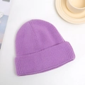 Close-up of light purple knitted beanie showing detailed wool texture on white table - One Size / Purple