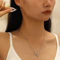 Silver stainless steel flying dragon necklace and earrings set worn by a model - Dragon Stud Earrings and Necklace Set (6641) / Steel