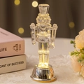 Transparent LED nutcracker soldier ornament with warm glowing light and silver base - Nutcracker Style B