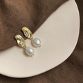 Detail of baroque pearl drop earrings featuring irregular gold metal studs and white pearls - Style 15