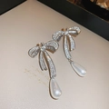 Détail macro de boucles d'oreilles nœud argentées avec strass et pendentifs perles gouttes - 16# Tige en Argent-Boucles d'Oreilles Noeud Argent