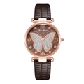 Close-up of rose gold watch dial featuring a glittery butterfly and leather strap - Brown