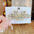 Funkelnde Kristall-Schmetterlings-Haarspange mit goldener Basis auf Schmuckkarte - Weiß