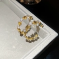 Close-up of gold star hoop earrings with sparkling cubic zirconia on a gray tray - Gold