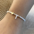 Bracciale di perle fatto a mano con cuore dorato e ciondolo lettera T sul polso - Lettera T