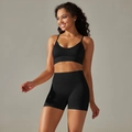 Detail of seamless black yoga set featuring V-neck sports bra and high-waist biker shorts - S / Top And Bottom / Cami Bra + Shorts / Black