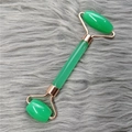 Dual-head green facial roller with rose gold metal frame on grey fur background - Green Roller